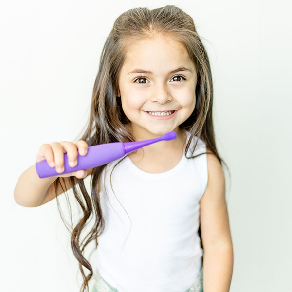 Girl holding an electric toothbrush